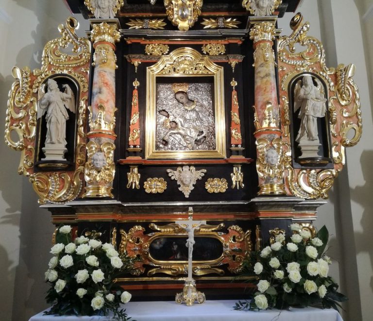 Ołtarz Matki Bożej Pocieszenia przybrany białymi kwiatami
